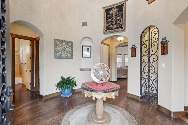 Foyer featuring visible vents, baseboards, wood finished floors, and arched walkways | Image 4
