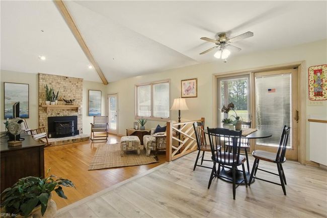 Den with wood stove, oak floors, and access to the back deck. | Image 22