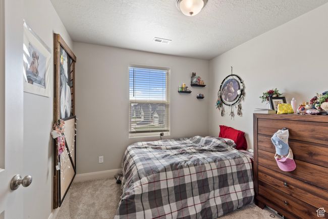 Bedroom featuring a textured ceiling, carpet floors, visible vents, and baseboards | Image 15