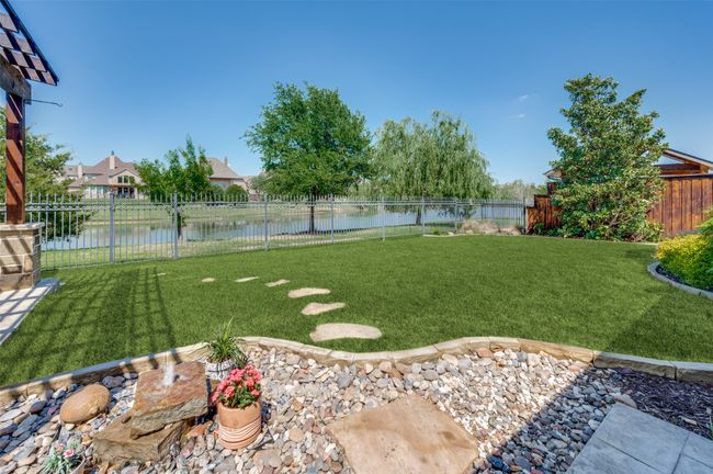 Enjoy beautiful water views of one of the neighborhood’s tranquil canals. A gated entry at the back of the property offers convenient access for fishing or peaceful strolls along the water. | Image 34