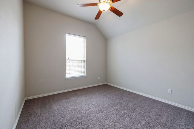 Spare room with dark colored carpet, a ceiling fan, and vaulted ceiling | Image 21