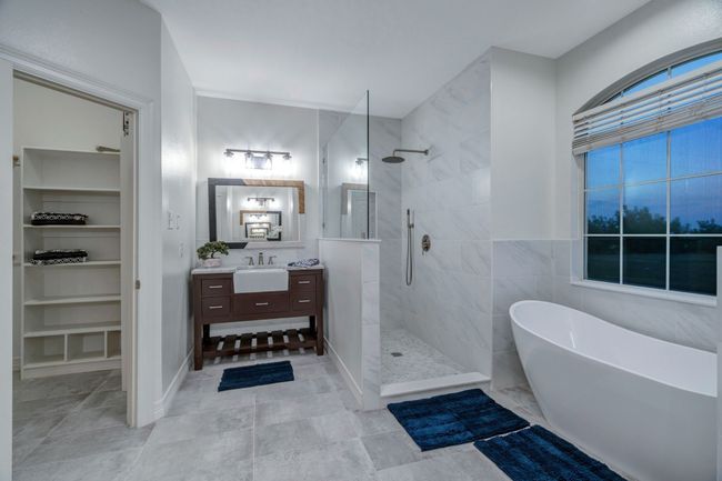 His and hers closets, pedistal sinks, walk-in shower and free-standing soaking tub add country charm to the ensuite bathroom. | Image 26