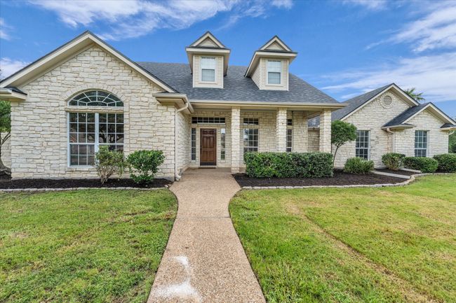 View of front of house featuring stone siding, a front lawn, and a shingled roof | Image 36