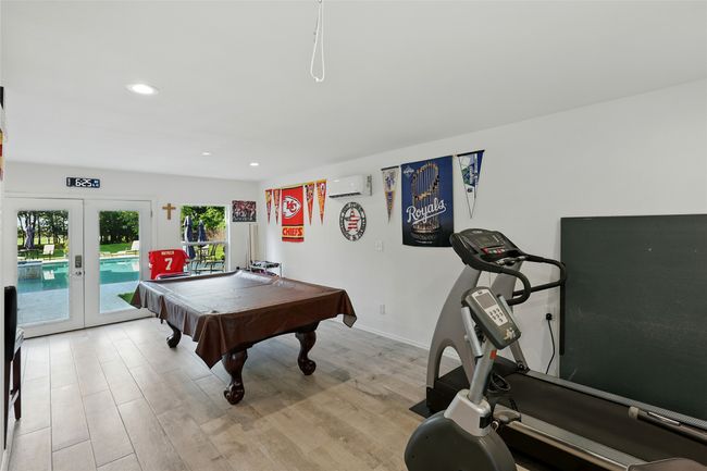 Pool House featuring french doors, light wood-type flooring, recessed lighting, and heat and AC wall unit. Could be used a sports center, gym, man cave! | Image 32