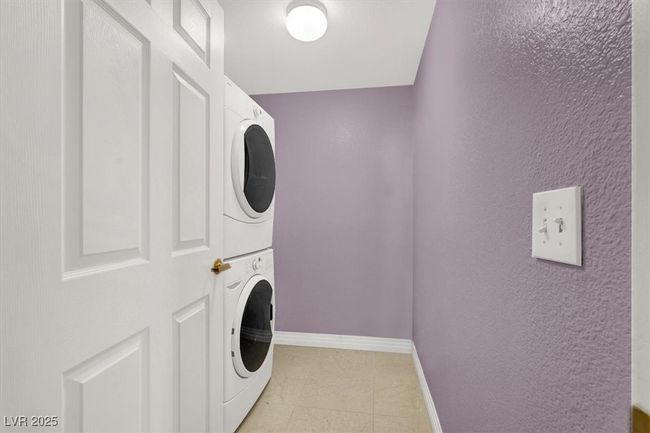 Laundry room with stacked washer / drying machine, laundry area, and baseboards | Image 30