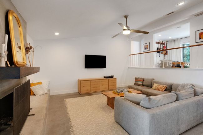 Living room with lofted ceiling, ceiling fan, a fireplace, and recessed lighting. | Image 12
