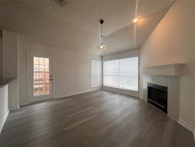 From kitchen, look out to this nice sized family room that completes the picture of a charming fireplace | Image 5