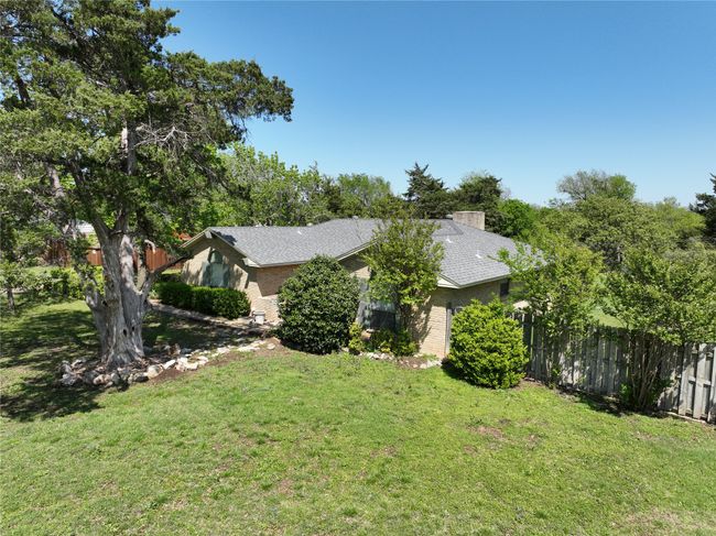View of side of home featuring a lawn, brick siding, and fence | Image 31