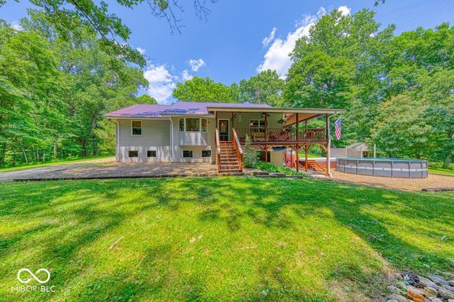 back of house featuring stairs, a lawn, a metal roof, and a wooden deck | Image 63