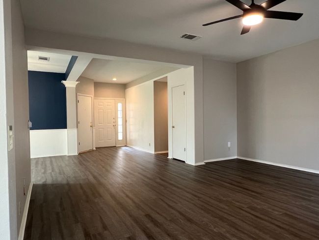 Unfurnished living room featuring dark wood-style floors and a ceiling fan | Image 16