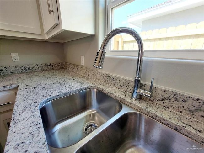 Kitchen view of light stone countertops and white cabinets | Image 9