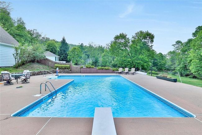 Sun drenched patio and pool featuring a diving board | Image 15