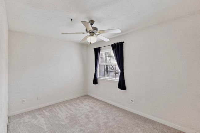 Empty room with carpet, ceiling fan, and a textured ceiling | Image 31