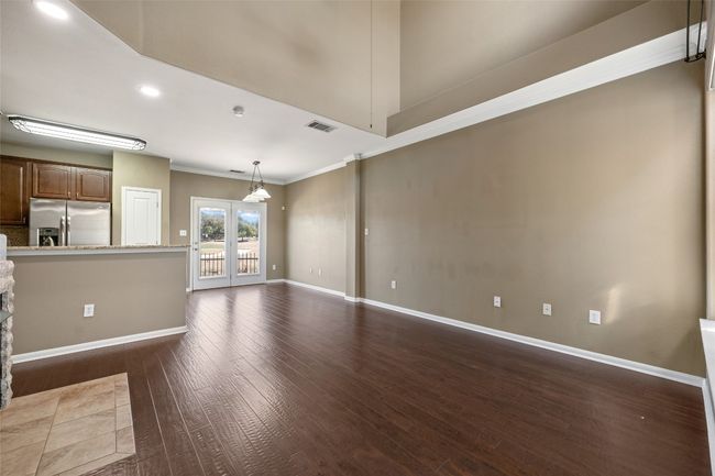 Unfurnished living room with wood floors, baseboards, and natural light. | Image 9