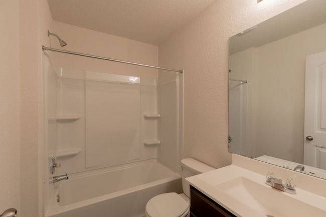 Full bathroom featuring toilet, vanity, shower / washtub combination, and a textured wall | Image 19