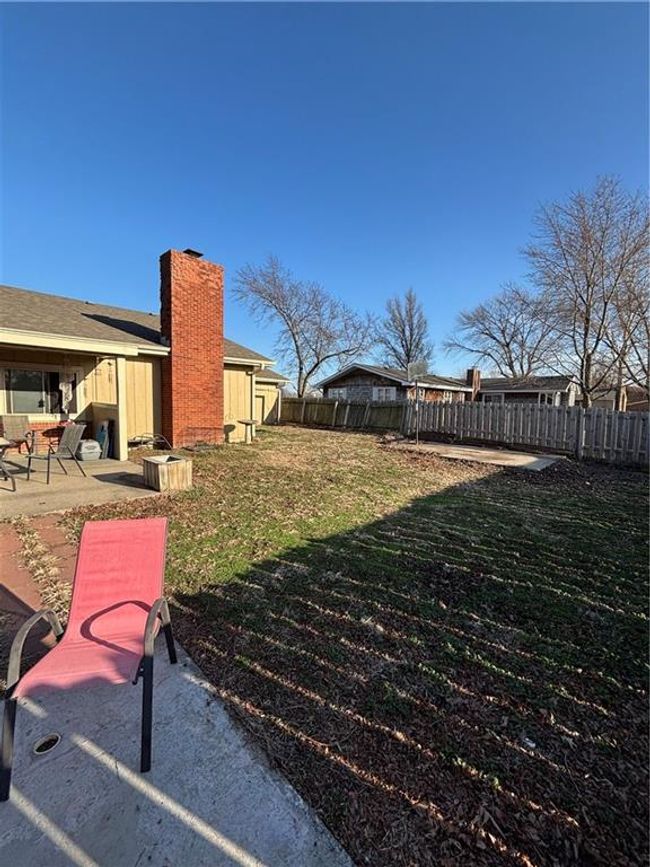 Large privacy fenced back yard with 2 seating/entertaining areas and a basketball pad | Image 29
