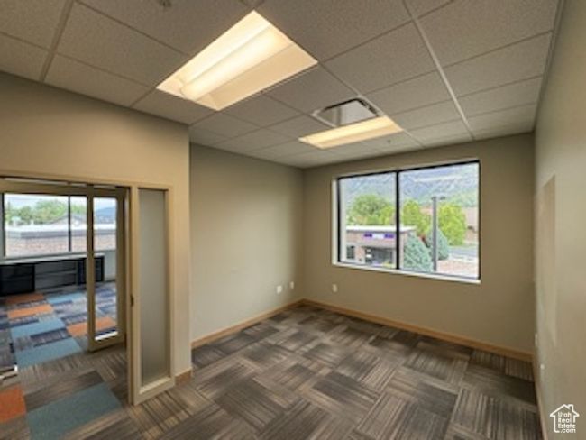 Carpeted empty room featuring a paneled ceiling and baseboards | Image 35