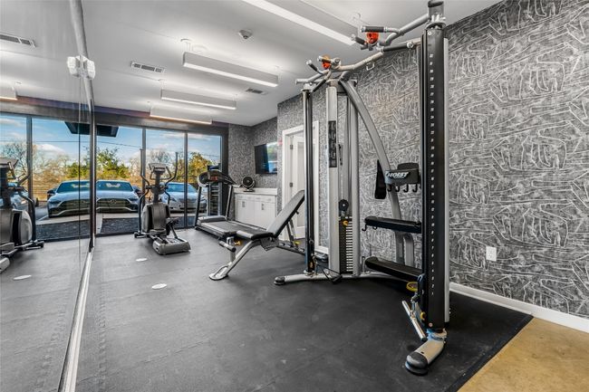 Gym featuring wallpapered walls, baseboards, and visible vents | Image 12