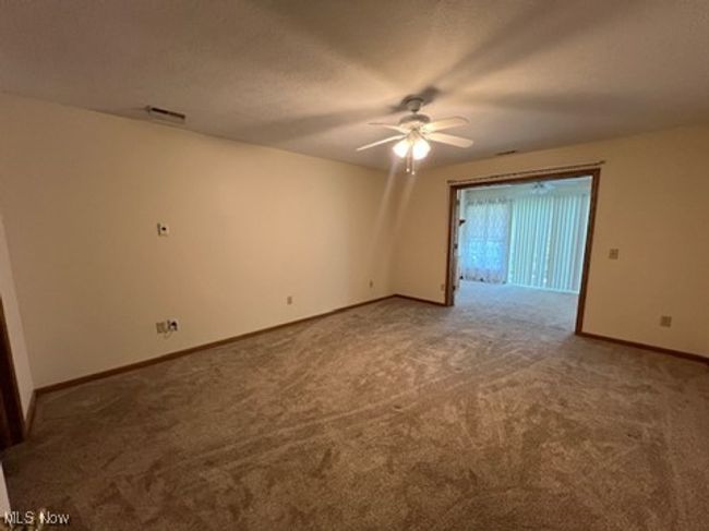 Carpeted spare room featuring ceiling fan and baseboards | Image 12