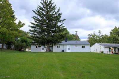 Rear view of property featuring central air condition unit and a yard | Image 3