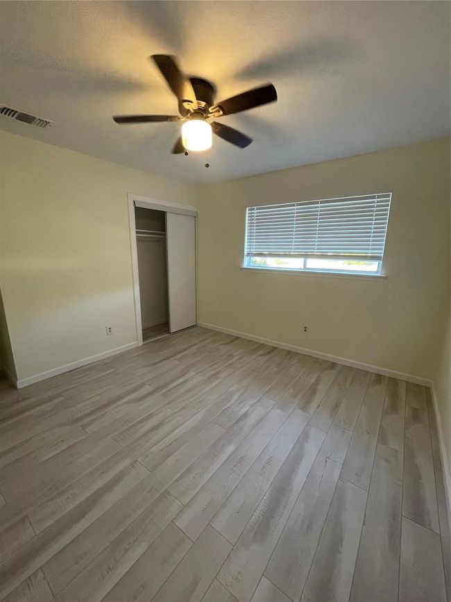 Unfurnished bedroom with light wood-type flooring, a closet, baseboards, and a ceiling fan | Image 14