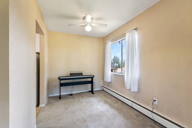 Unfurnished room with a baseboard radiator, ceiling fan, carpet, and baseboards | Image 18