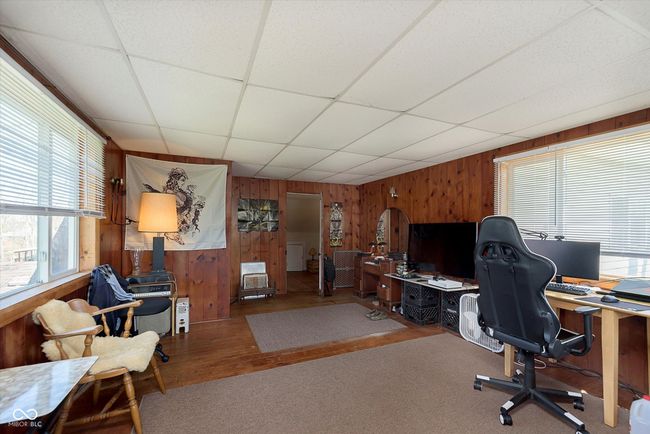office area with wooden walls, a drop ceiling, arched walkways, and wood finished floors | Image 20