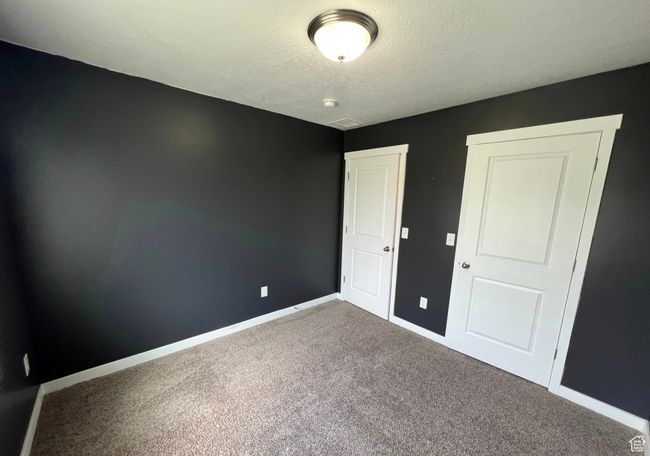 Unfurnished bedroom with carpet floors and a textured ceiling | Image 22