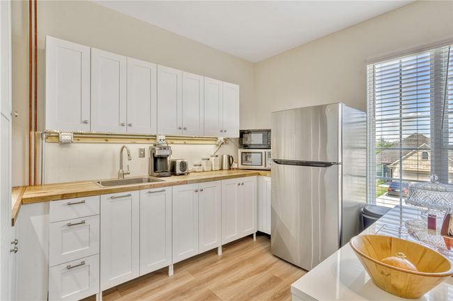 Kitchen featuring appliances with stainless steel finishes, plenty of natural light, wooden counters, and light wood-style floors | Image 26