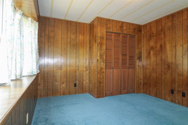 Spare room with wood walls and carpet floors | Image 16