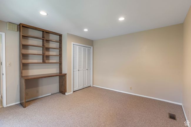 Unfurnished bedroom with light colored carpet, baseboards, visible vents, and recessed lighting | Image 24