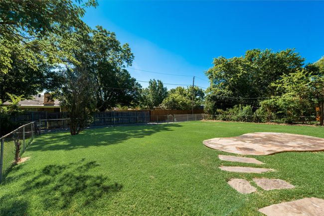 View of yard featuring a fenced backyard and a patio area | Image 26