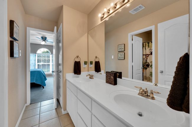 Ensuite bathroom featuring double vanity, ceiling fan, and tile patterned floors | Image 26