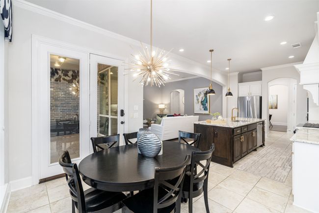 Dining area has access to back patio and opens to the kitchen. Take note of the beautiful light fixture and crown molding. | Image 17