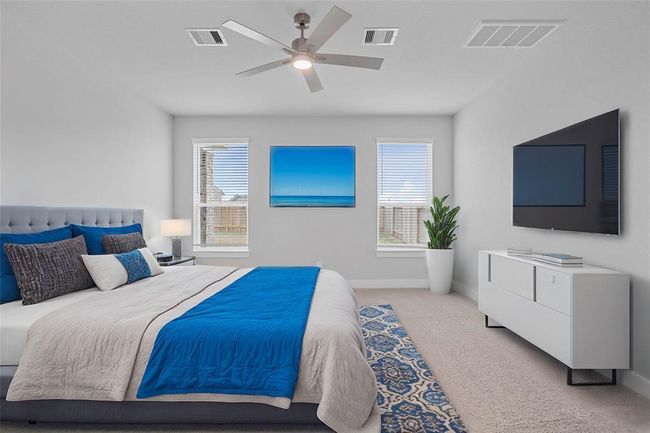 Come and unwind after a long day in this magnificent primary suite! This spacious room features plush carpet, warm paint, high ceilings with ceiling fan and large windows with privacy blinds. | Image 10