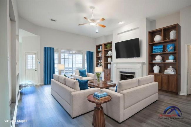 The space is virtually staged with modern furniture, a wall-mounted TV, and tasteful decor, creating a welcoming atmosphere. | Image 19