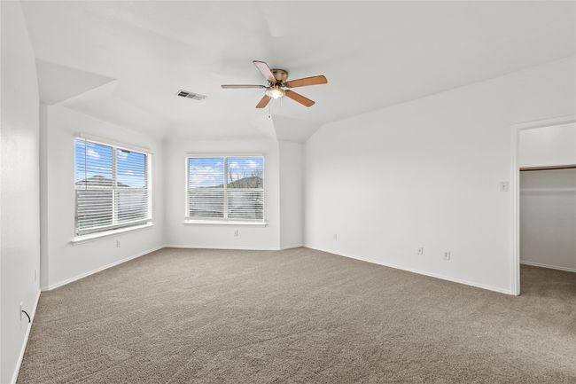 Unfurnished bedroom with a walk in closet, carpet flooring, baseboards, and visible vents | Image 12