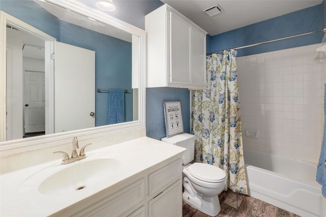Full bathroom featuring visible vents, toilet, shower / bathtub combination with curtain, vanity, and wood finished floors | Image 22