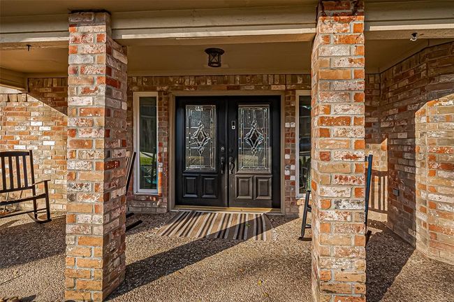 Welcome home to elegant double glass doors and a serene covered porch. | Image 7