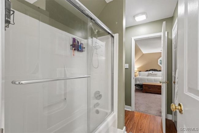 Ensuite bathroom featuring wood finished floors and enclosed tub / shower combo | Image 34
