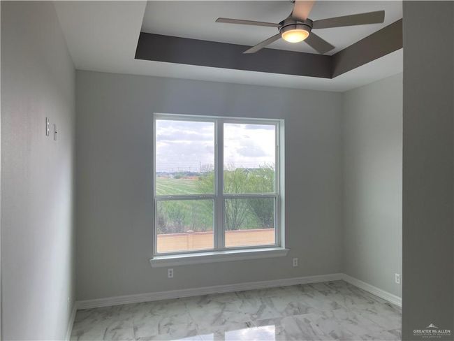 Spare room featuring light marble finish flooring, ceiling fan, and baseboards | Image 10