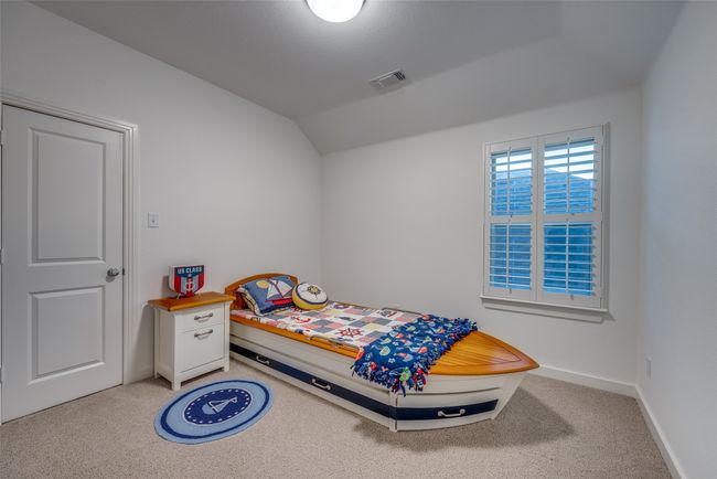 Bedroom featuring baseboards, visible vents, light colored carpet, and vaulted ceiling | Image 24