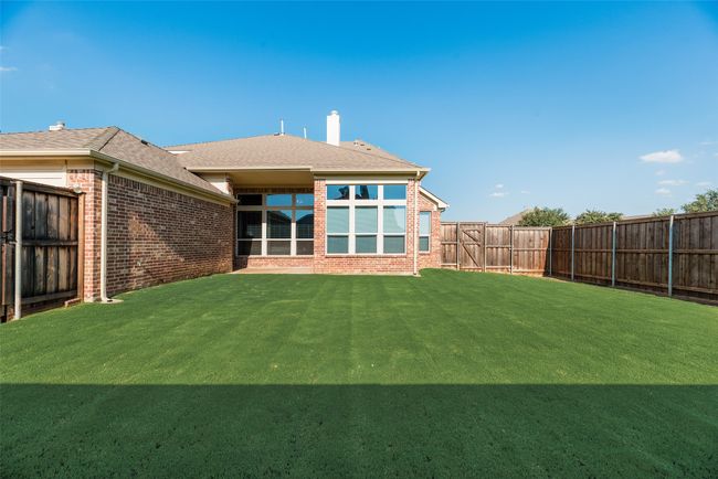 Back of property featuring brick siding, a fenced backyard, roof with shingles, and a chimney | Image 29