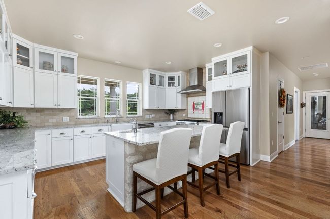 A spacious island anchors the kitchen, providing extra seating and prep space. | Image 12
