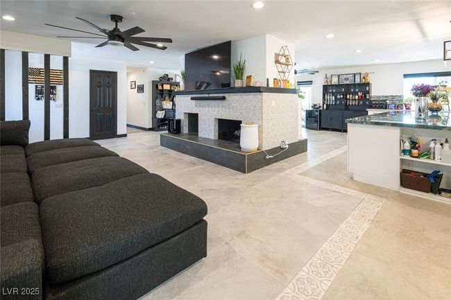 Living area with recessed lighting, ceiling fan, and a tile fireplace | Image 8