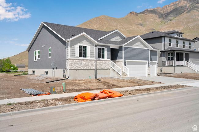 View of front of house with a mountain view, stone siding, and concrete driveway | Image 36