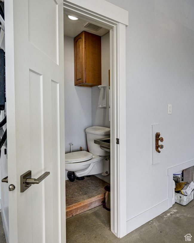 Bathroom featuring unfinished concrete floors and toilet | Image 111