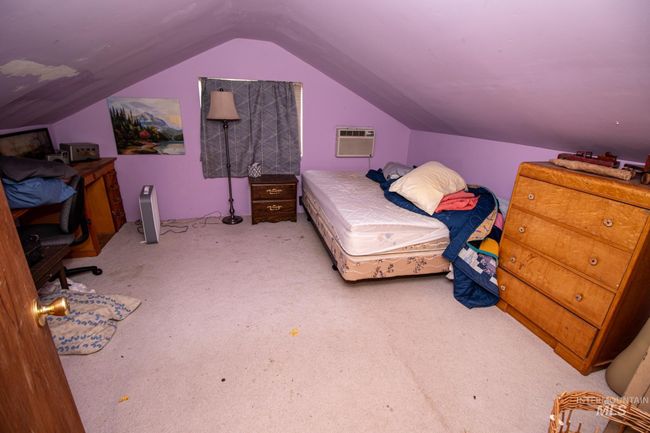 Bedroom featuring carpet floors, vaulted ceiling, and a wall mounted air conditioner | Image 34