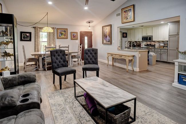 Living room featuring lofted ceiling, light vinyl floors, and recessed lighting | Image 8
