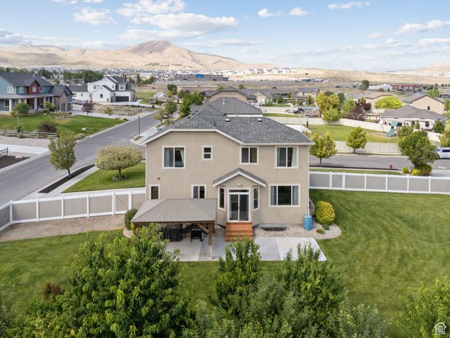 Back of house featuring a fenced backyard, a mountain view, a residential view, stucco siding, and a gazebo | Image 56